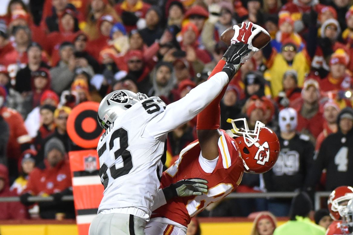 Kansas City tight end Demetrius Harris, right, pulls in a touchdown pass as he's defended by Oakland's Malcolm Smith on Sunday, January 3. It was the first touchdown of his NFL career, and Kansas City won the game 23-17.