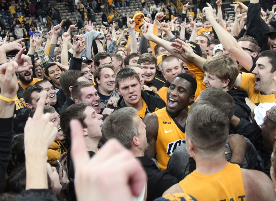 Iowa guard Anthony Clemmons, center, celebrates with fans who stormed the court after the Hawkeyes upset No. 1 Michigan State on Tuesday, December 29. It was Michigan State's first loss of the season.