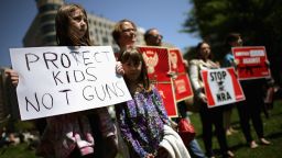 WASHINGTON, DC - APRIL 25:  Anti-gun violence demonstrators, including Rachel Ahrens (L), 13, Abby Ahrens, 8, and their mother Betty Ahrens hold signs condeming the National Rifle Association during a protest in McPhearson Square April 25, 2013 in Washington, DC. Angry with the U.S. Senate's failure to pass an expansion of background checks for people wanting to buy guns, the demonstrators attempted to deliver faux bank checks and crime scene photos to a handful of lobbying firms that represent the NRA.  (Photo by Chip Somodevilla/Getty Images)