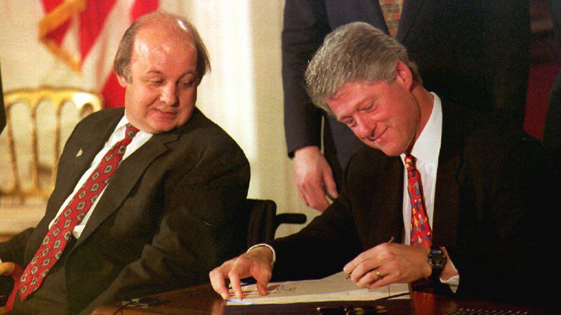 James Brady, the Reagan Administration press secretary who was wounded during the 1981 attempted assassination on Ronald Reagan, watches as Bill Clinton signs the Brady Bill at the White House on 30 November 1993.