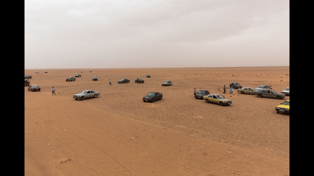 Cars wait on the outskirts of Zouérat to pick up passengers after the train ride.