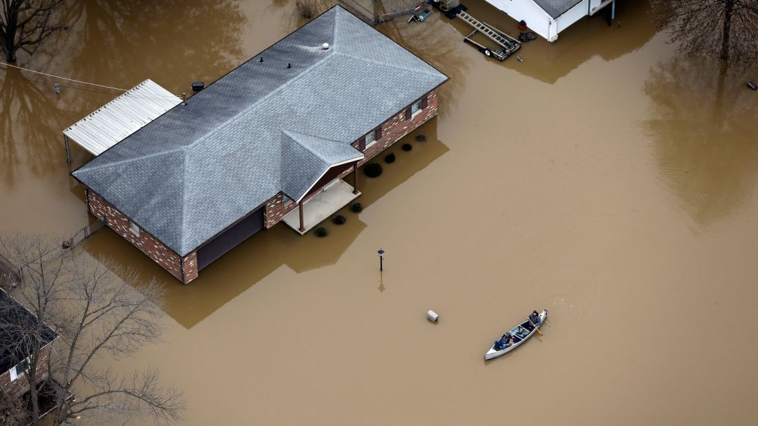 In this aerial photo, people use a canoe to navigate a flooded street on December 31 in Arnold, Missouri. Up to a foot of rain fell in parts of Missouri and Illinois, surging the Mississippi River and many of its tributaries to record levels. As many as 13 people died in Missouri alone and hundreds more were evacuated as the flooding threatened dozens of levees, many in the St. Louis area.