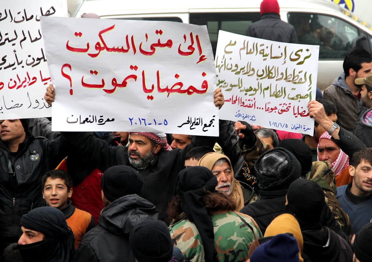 Demonstrators in Idlib, Syria, hold banners in a protest for civilians in besieged Madaya on Tuesday, January 5.