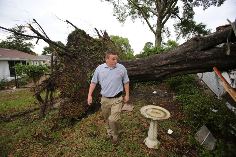 James Lucas, the public information officer for Marion County Fire Rescue, walks past a large oak tree that went through a home during severe weather in Ocala, Florida, on April 20. Nearly 40 tornadoes occurred from April 18-20 in 11 states across the South and Southeast. 