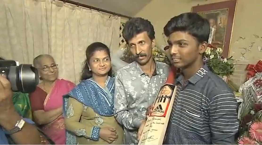 Pranav poses with his Mum and Dad as the world's media descend on the family's home in Mumbai.