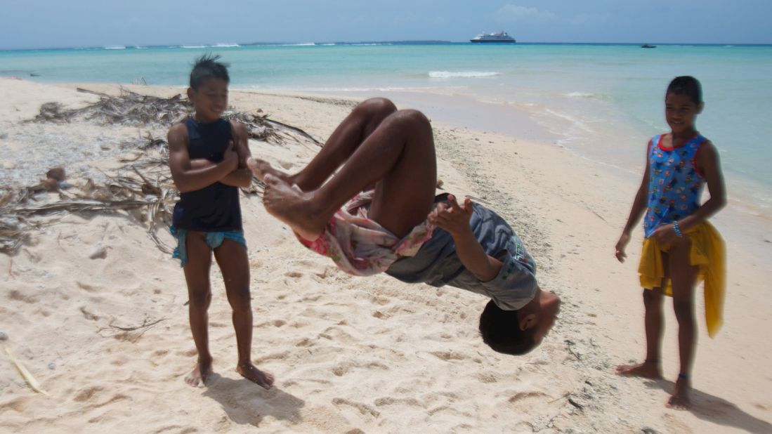 Micronesia's 607 islands are home to a vanishing way of life. Pulap Atoll's children show off their acrobatic prowess while the author's cruise ship waits outside the barrier reef. 