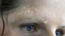 Sweat is seen on the forehead of German rowing athlete Christine Huth at the Gym at the Athlete's Olympic Village in Beijing on August 5, 2008, three days ahead of the start of the 2008 Beijing Olympic Games. The 2008 Beijing Olympic Games will take place in China between August 8 and 24.