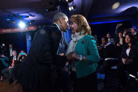 Obama greets former U.S. Rep. Gabby Giffords during a commercial break. Giffords was shot in an assassination attempt in 2011.
