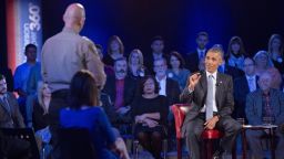 President Barack Obama, right, answers questions from Arizona Sheriff Paul Babeu, left standing, during a CNN televised town hall meeting at George Mason University in Fairfax, Va., Thursday, Jan. 7, 2016. Obama's proposals to tighten gun controls rules may not accomplish his goal of keeping guns out of the hands of would-be criminals and those who aren't legally allowed to buy a weapon. In short, that's because the conditions he is changing by executive action are murkier than he made them out to be. (AP Photo/Pablo Martinez Monsivais)
