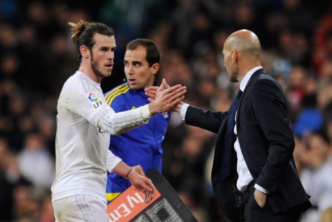 Zidane (R) shakes hand with Bale as he leaves the field.