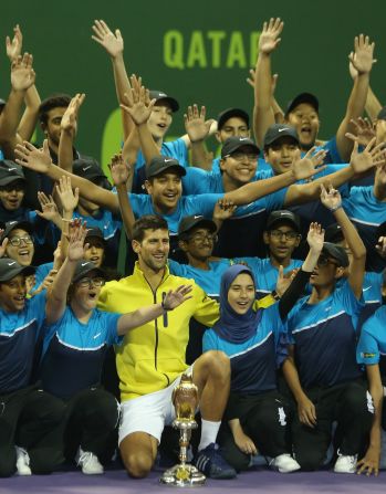 Novak Djokovic poses for a picture with the tournament's ballboys and girls after thrashing Rafael Nadal of Spain in the final Qatar Open in Doha.