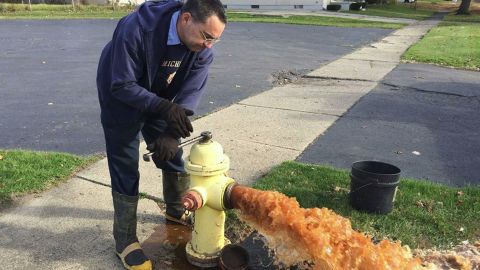 A city employee flushes out a hydrant.