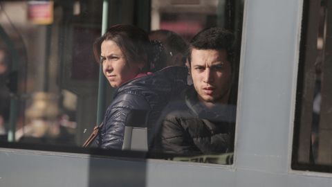 People on a tram look out the window as it drives past the tourism hub where the explosion occurred.
