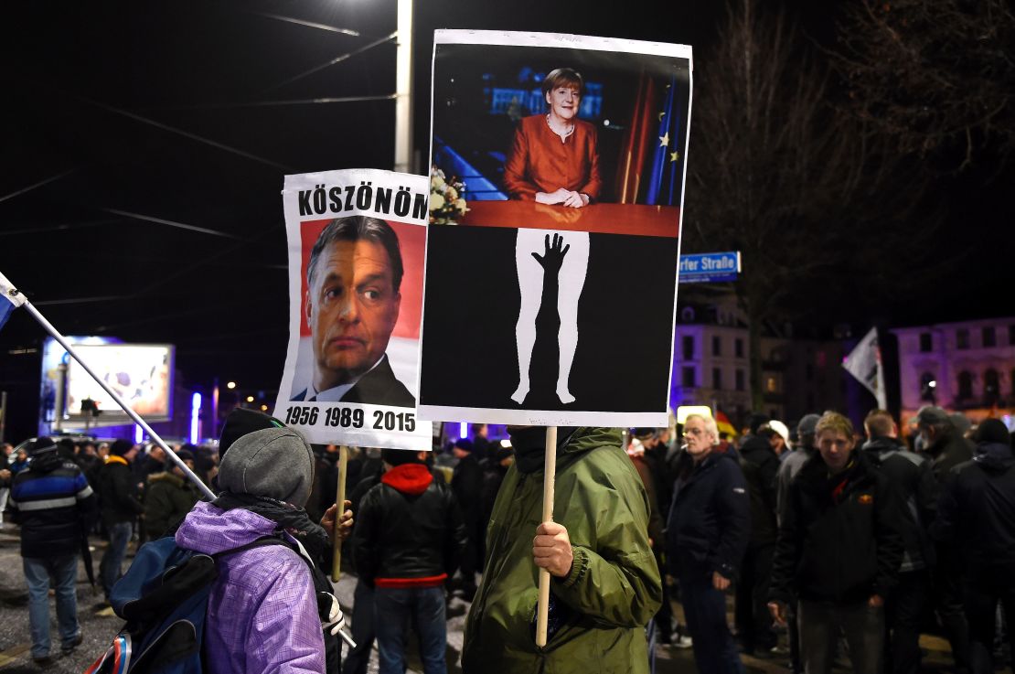 Protesters in Leipzig hold aloft posters depicting German Chancellor Angela Merkel being groped and of Hungarian PM Viktor Orban, known for his anti-migrant stance. The latter reads "Thanks" in Hungarian.
