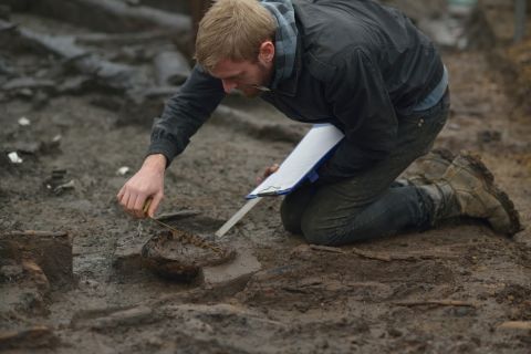 Wood specialist Mike Bamforth examines the base of a Bronze Age wooden bucket.