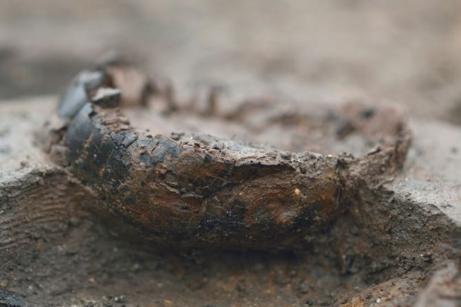 A close up of a charred wooden bucket base.