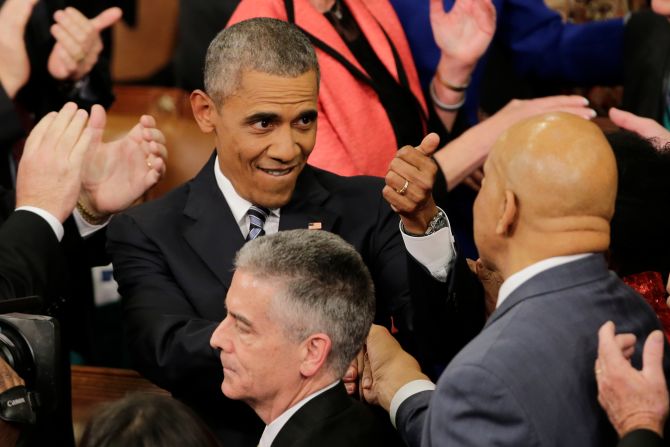 Obama gestures to an attendee as he arrives.