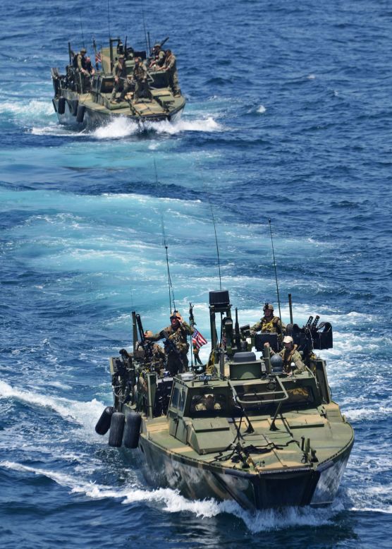 A riverine command boat approaches the USS New York in June 2012.