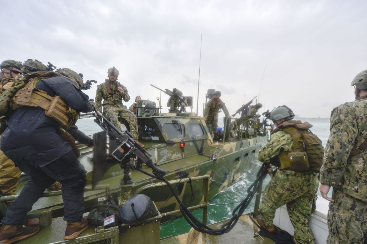 Sailors secure a towline to a riverine command boat during a training exercise.