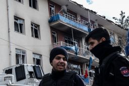 Turkish riot police guard a damaged building in  Diyarbakir.