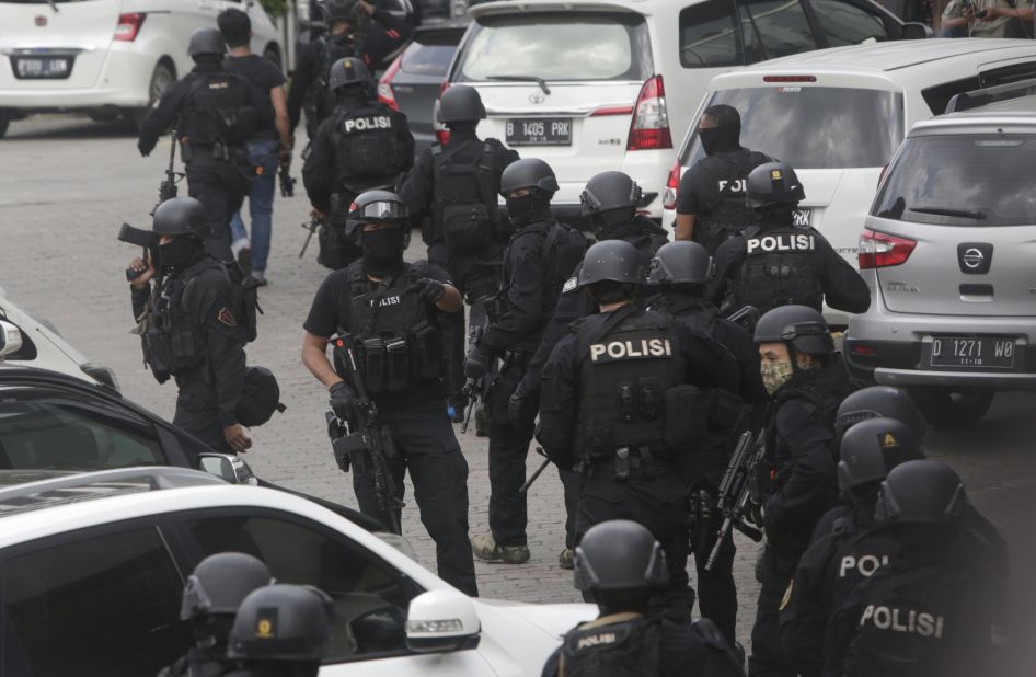 Police officers are deployed near the site where a series of blasts rocked downtown Jakarta on January 14.