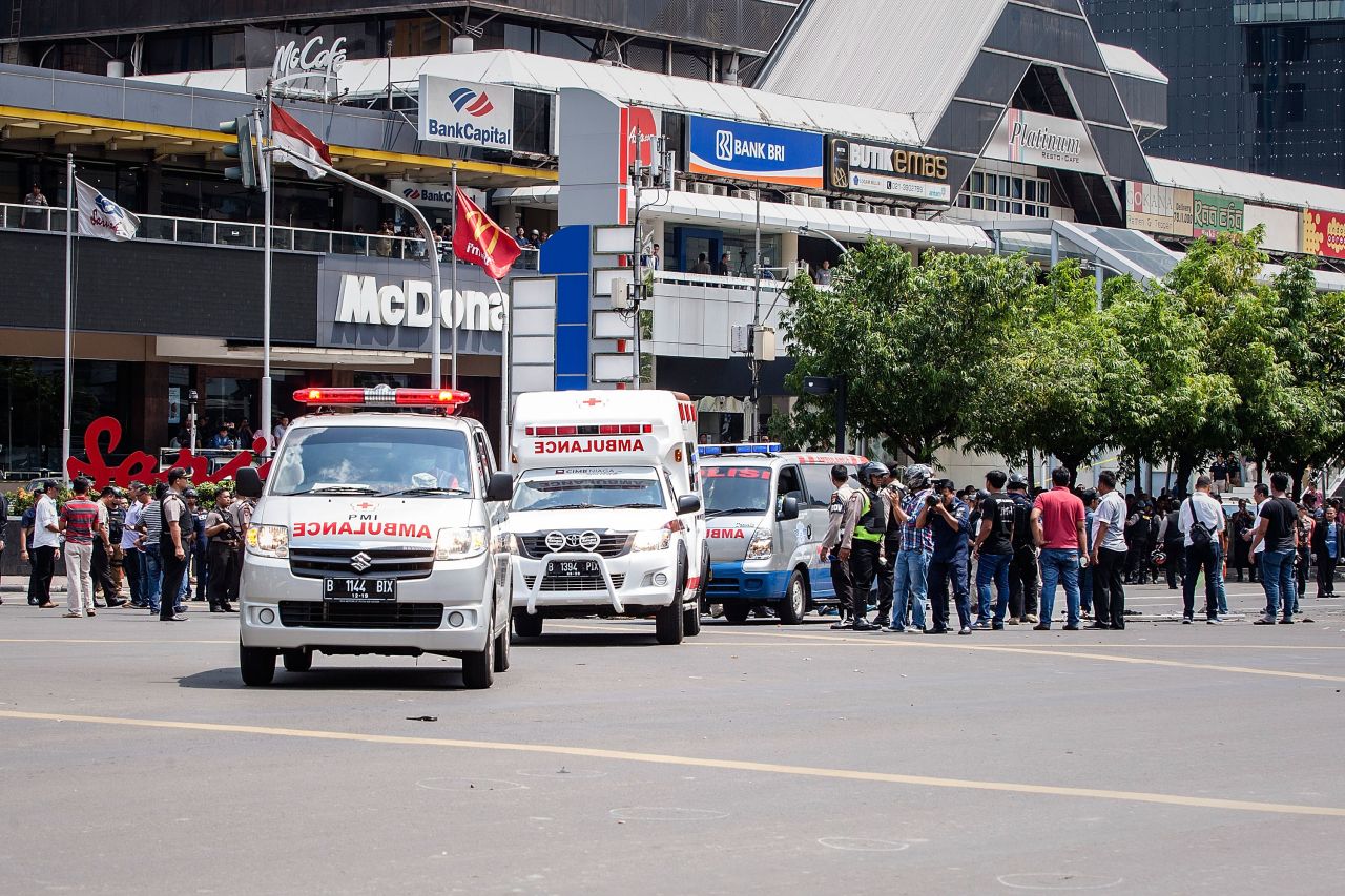 Police and ambulances arrive in front of the Sarinah shopping center, next to a police station targeted by the attacks, on January 14.