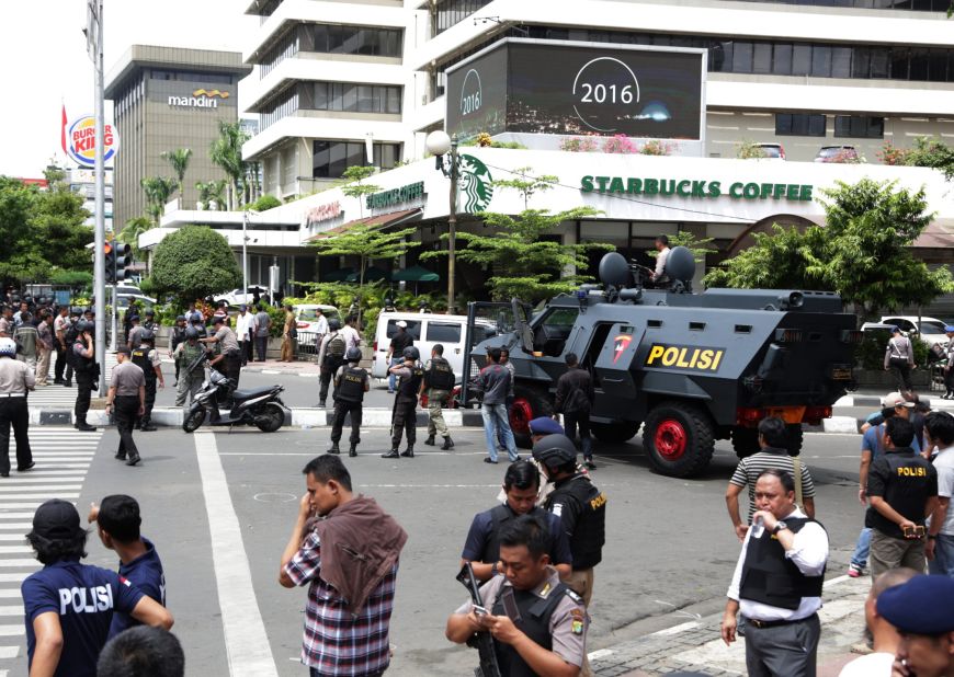 Police officers stand guard outside a Starbucks cafe in Jakarta's bustling shopping area, near the site of an explosion, on January 14.