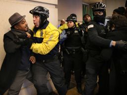 Protesters scuffle with police outside the hotel where the breakfast took place. 