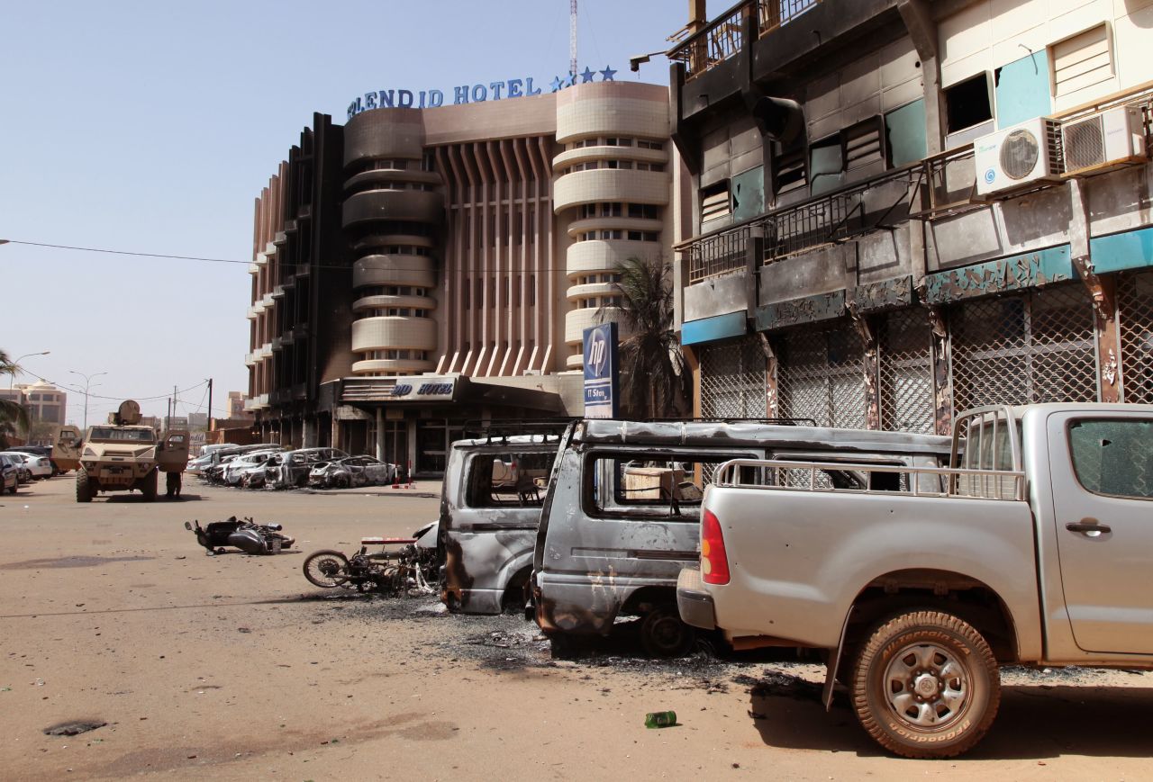 Burnt-out cars sit in front of the Splendid Hotel after an overnight attack in Ouagadougou, Burkina Faso, on Saturday, January 16. Attackers raided the luxury hotel late Friday, opening fire and seizing hostages in a siege that lasted several hours and ended with at least 23 people dead.