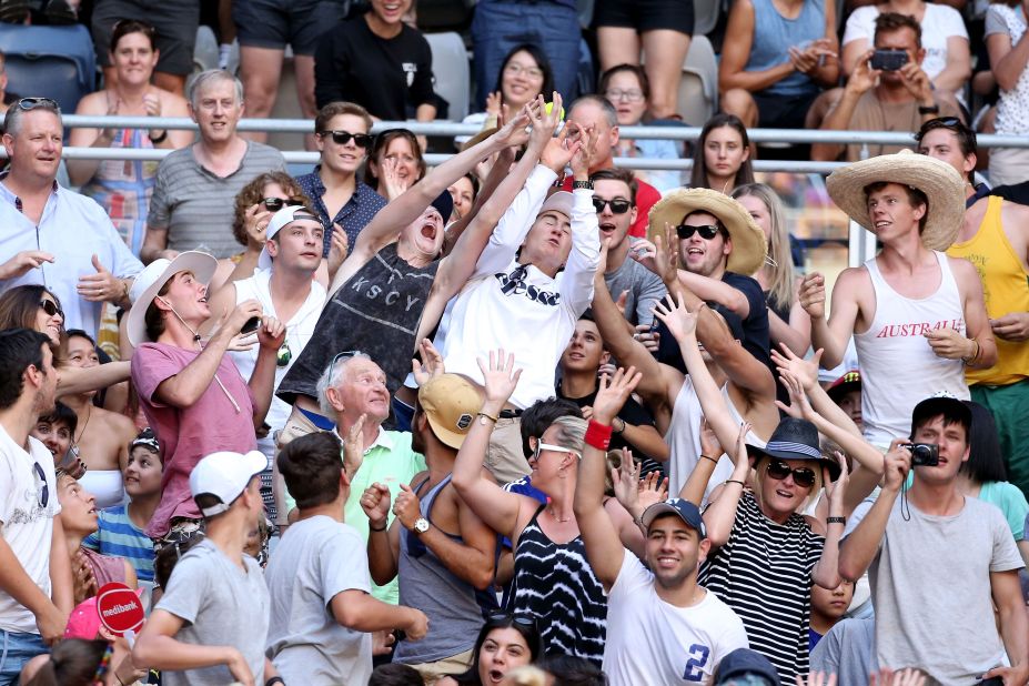 Fans attempt to catch a stray tennis ball during the match between Wozniacki and Putintseva.