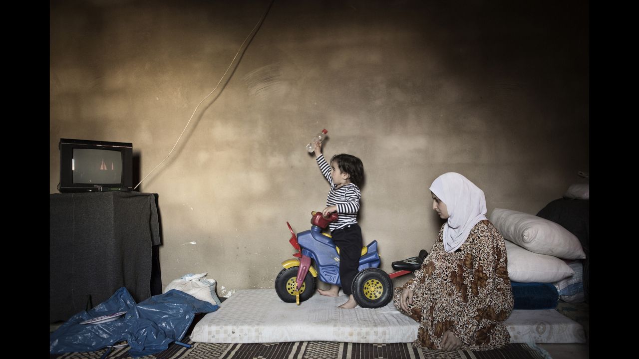 Marwa, 15, watches her son play on a tricycle. She married three years ago and left Syria a year after that.