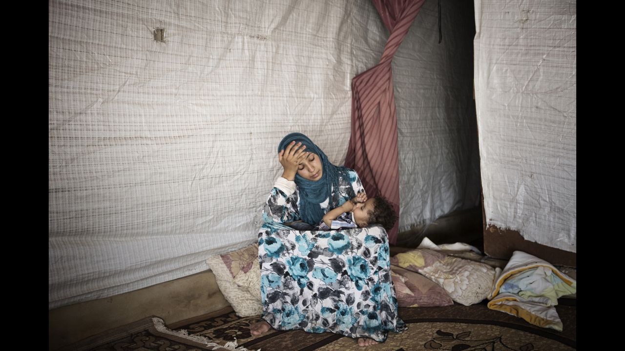 Amina, 14, holds her son in her arms. She got married about two years ago, and she has two sons.