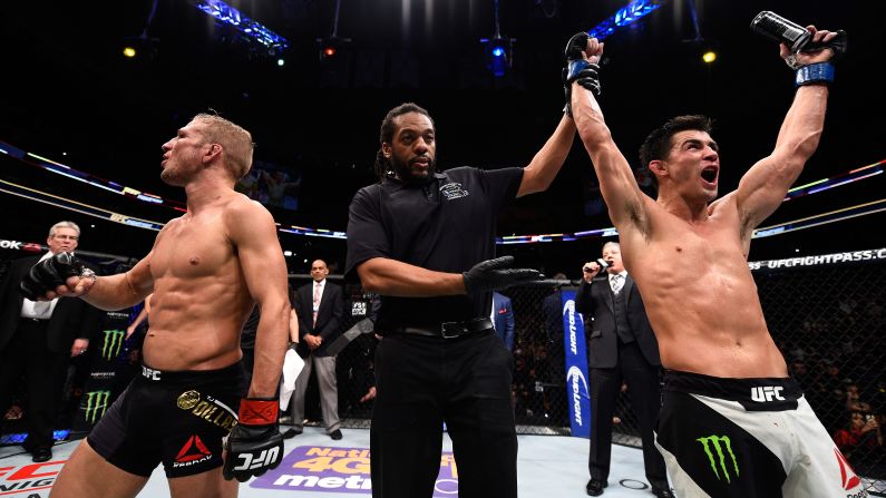 Referee Herb Dean raises the hand of Dominick Cruz after Cruz defeated T.J. Dillashaw to win the UFC bantamweight title in Boston on Sunday, January 17. Cruz won by split decision, regaining the title that was stripped from him because of injuries.