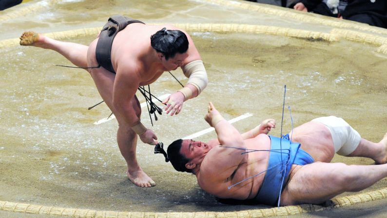 Hakuho throws Aoiyama to win a match at the New Year Grand Sumo Tournament in Tokyo on Thursday, January 14.