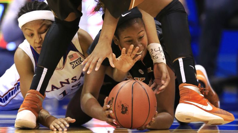 Kansas' Aisia Robertson, left, and Texas' Ariel Atkins dive for a loose ball during a game in Lawrence, Kansas, on Wednesday, January 13.