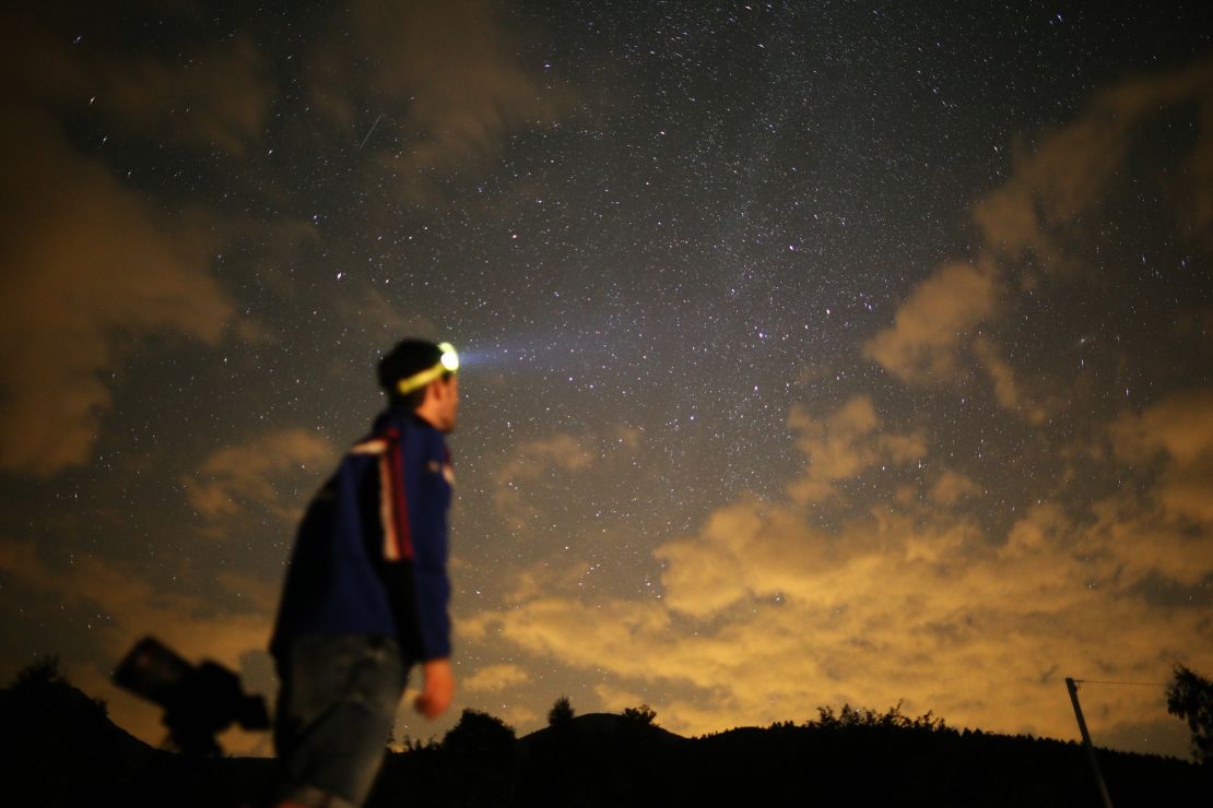 A photographer prepares to take pictures of a meteor shower in the village of Crissolo, near Cuneo, in the Monviso Alps region of northern Italy.