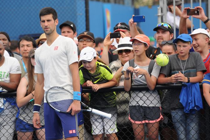Fans get up close and personal to Novak Djokovic during a practice session at Melbourne Park.