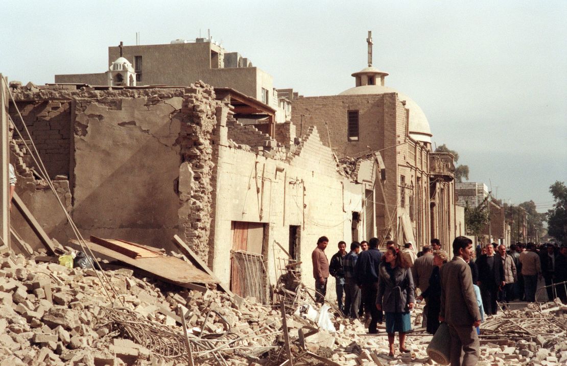 A photo taken on February 16, 1991 shows Iraqi civil defence workers and civilians looking at the damage near a Christian church caused by an allied bombing raid in Baghdad.