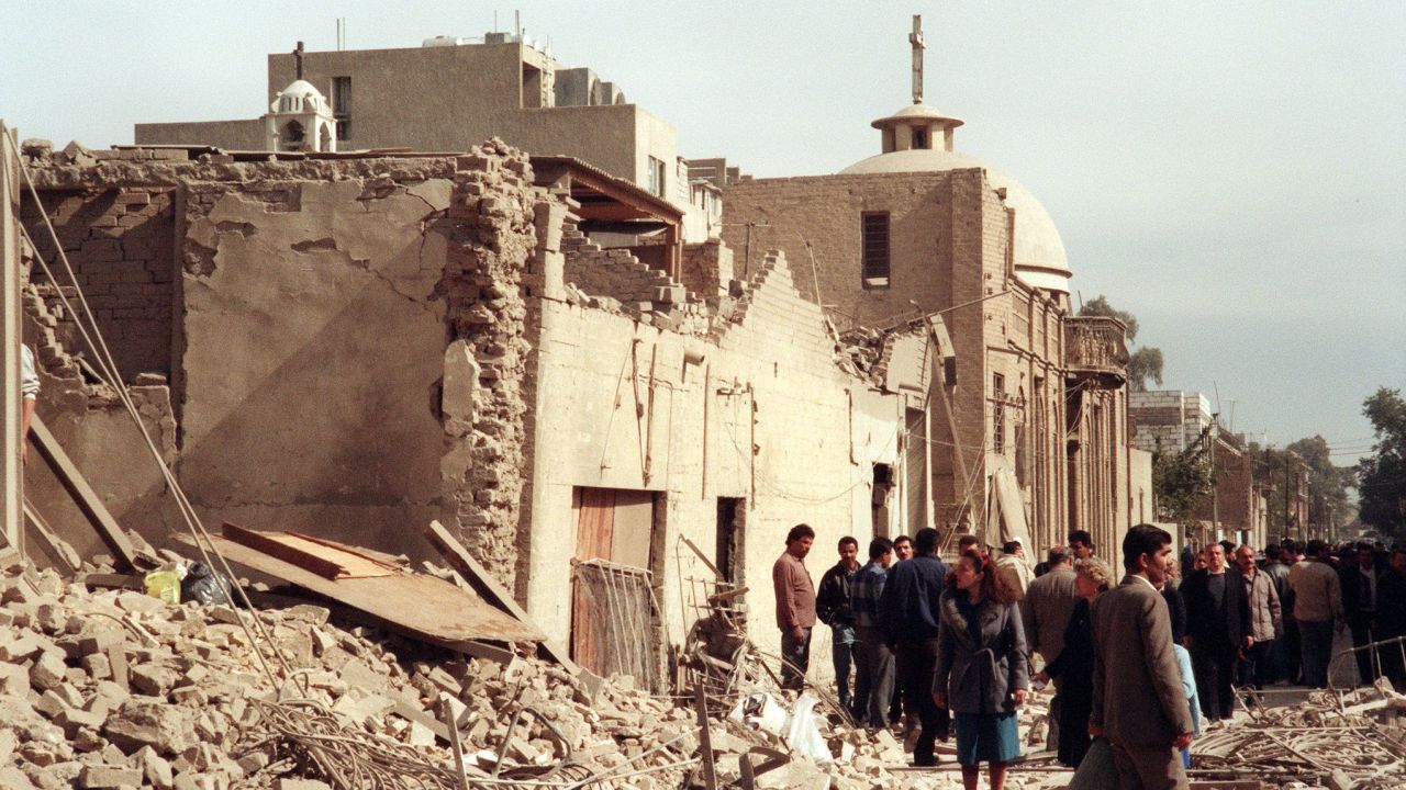 A photo taken on February 16, 1991 shows Iraqi civil defence workers and civilians looking at the damage near a Christian church caused by an allied bombing raid in Baghdad.