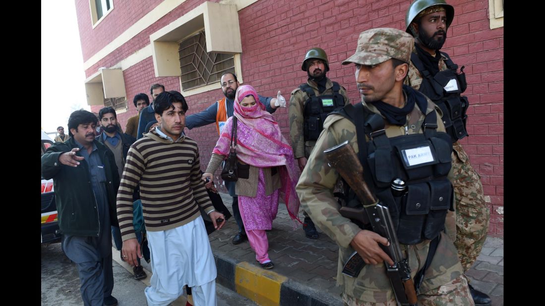 Pakistani soldiers lead people from the university.