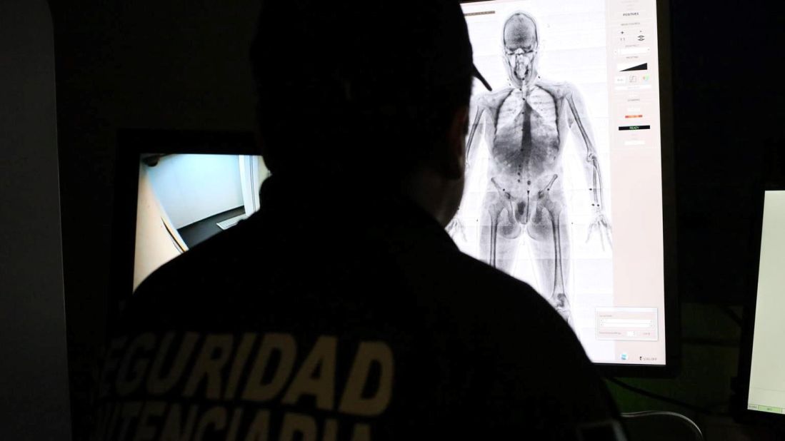 An officer operates the body scan machine.