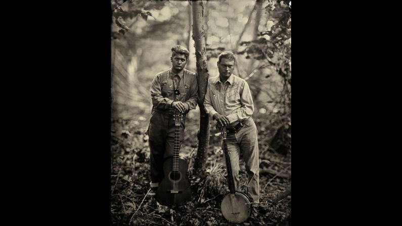 Matthew Kinman and Moses Nelligan lean against a tree.