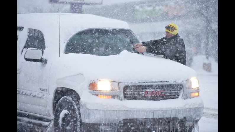A man cleans his windshield wipers at a stop light in Bowling Green on January 22.