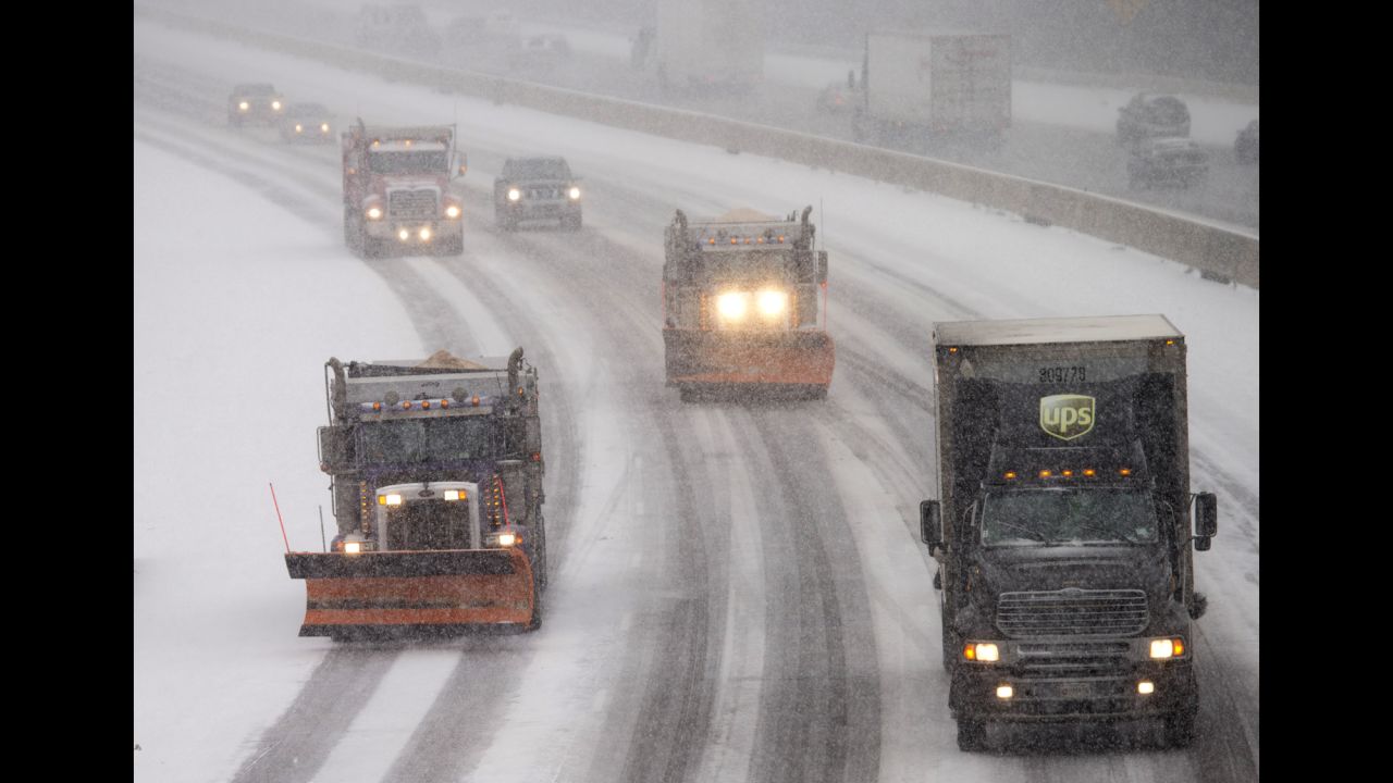 Snow plows make their way north along Interstate 95 as snow begins to fall in Ashland, Virginia, on January 22.