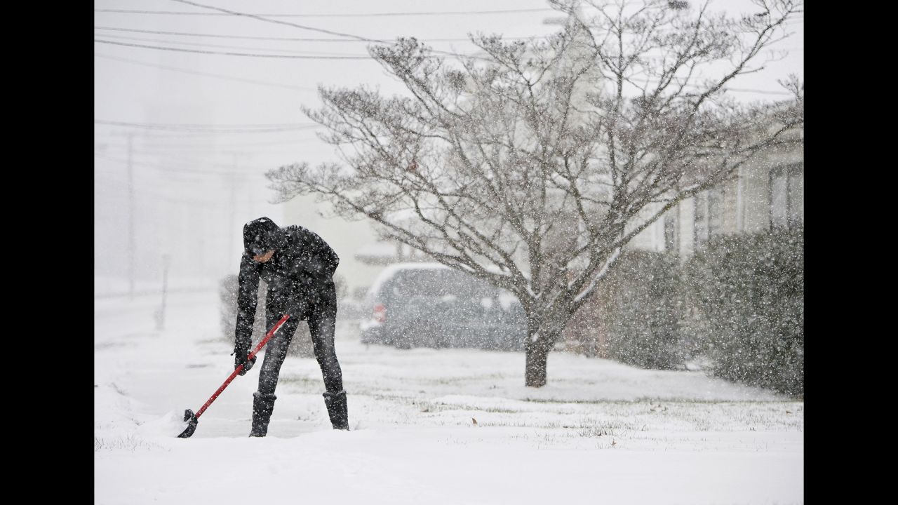 A woman in Lynchburg shovels the sidewalks in front of her house on January 22.