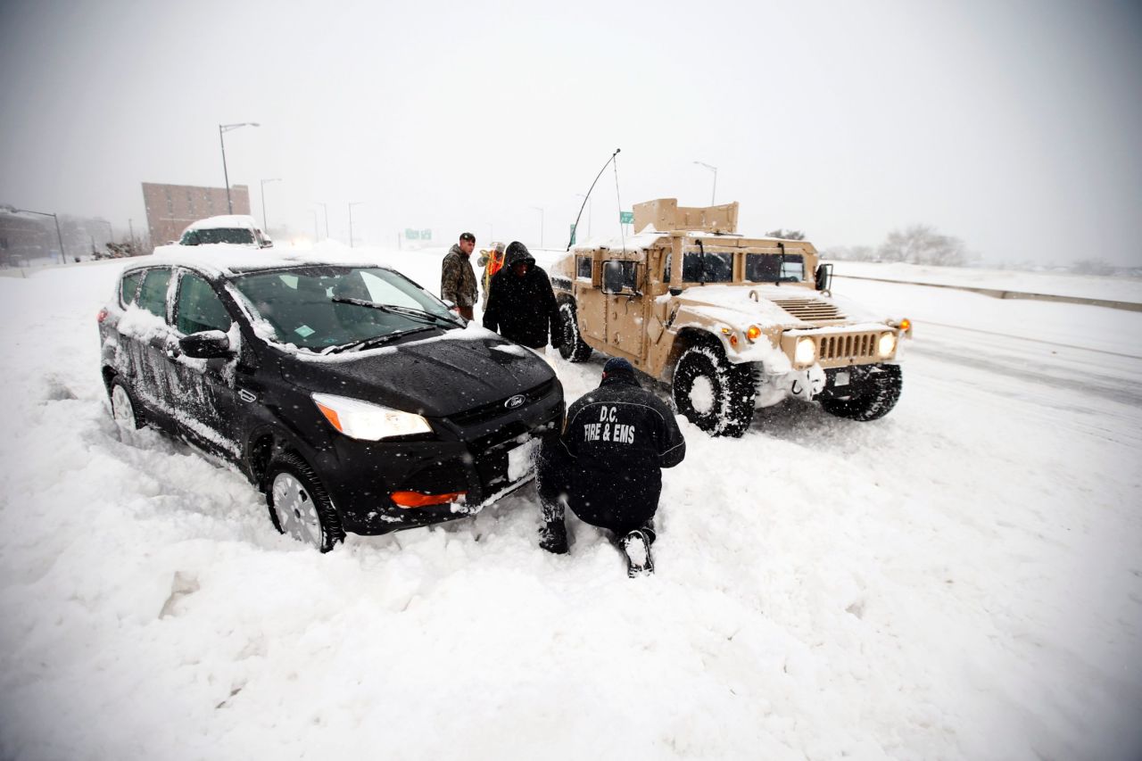 Soldiers and a Washington firefighter in a Humvee assist a stranded motorist in Washington on January 23.