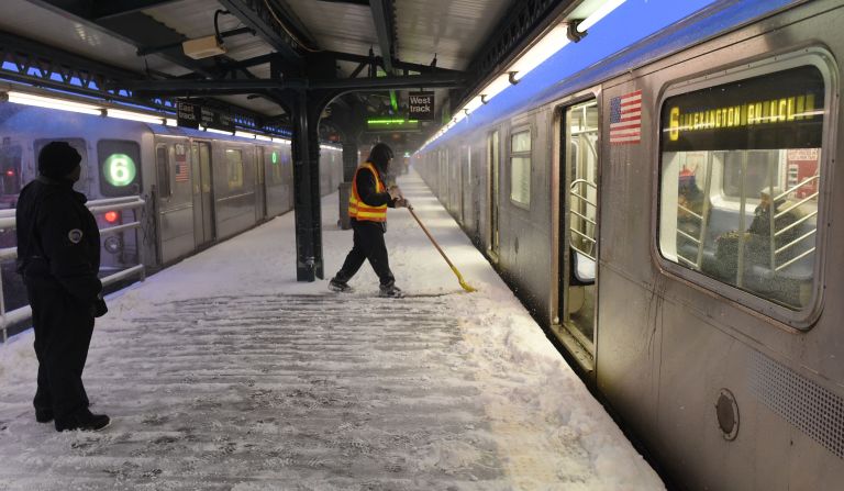 A New York City transit worker shovels snow from a subway platform on January 23.