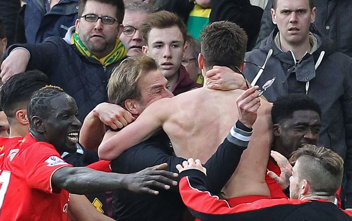 A shirtless Adam Lallana celebrates with teammates and manager Jurgen Klopp as Liverpool claim a dramatic 5-4 victory at Norwich City.