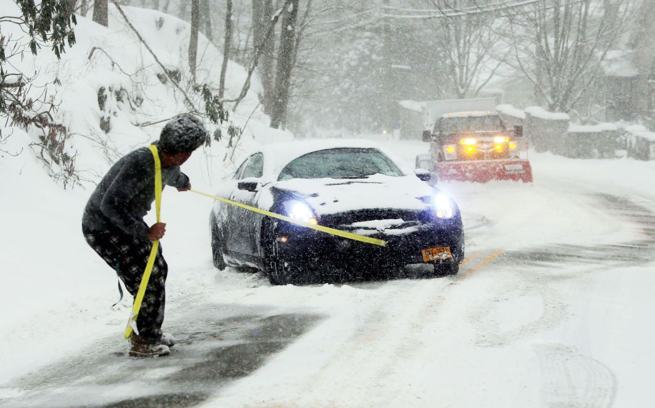 Michael McDonald attempts to pull his friend's car out of snow in Irvington, New York, on January 23. As his friend steered and gently accelerated, McDonald was able to get the car out of the snow and up the hill. 