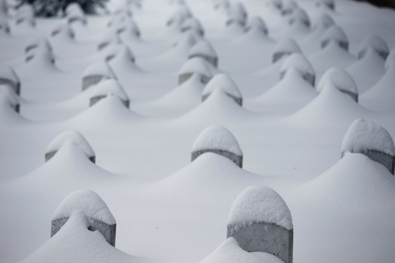 Headstones jut from the snow at Arlington National Cemetery.